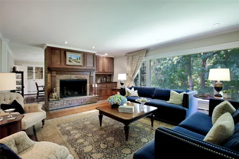 a living room with furniture a large window and a fireplace