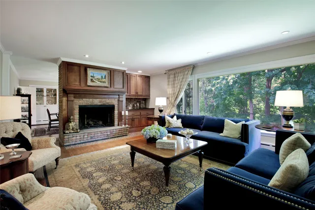 a living room with furniture a large window and a fireplace