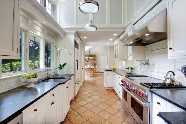 a large kitchen with stainless steel appliances granite countertop a lot of counter space and a sink