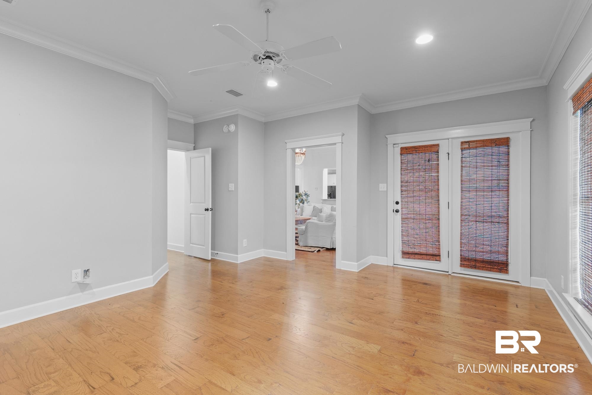 11261 Halcyon Loop Daphne, AL 36526 - Photo 26 of 41 Spacious room featuring wood-finish flooring, light grey walls, and white crown molding