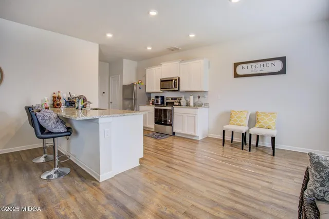 a kitchen with a dining table chairs and refrigerator