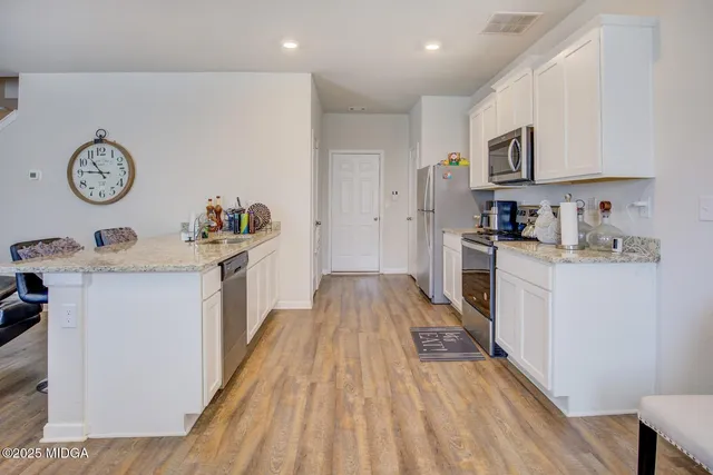 a kitchen with cabinets a stove and wooden floor