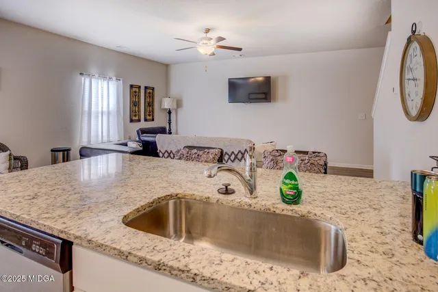 a kitchen with a sink a faucet a stove and white cabinets