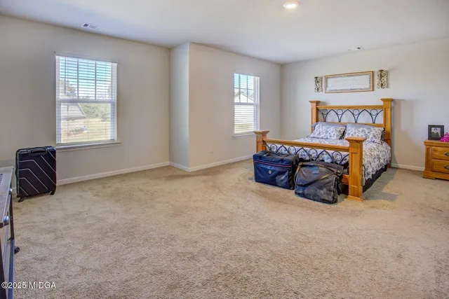 a bed sitting in a bedroom next to a window and a larger closet