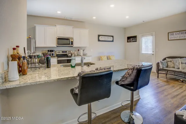 a living room with furniture and kitchen view