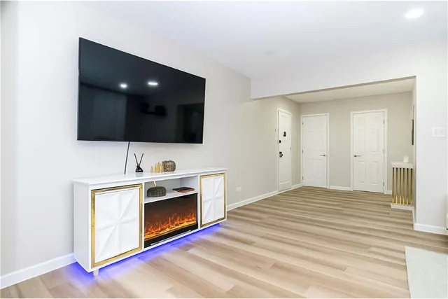 a view of an empty room with a fireplace and a flat screen tv