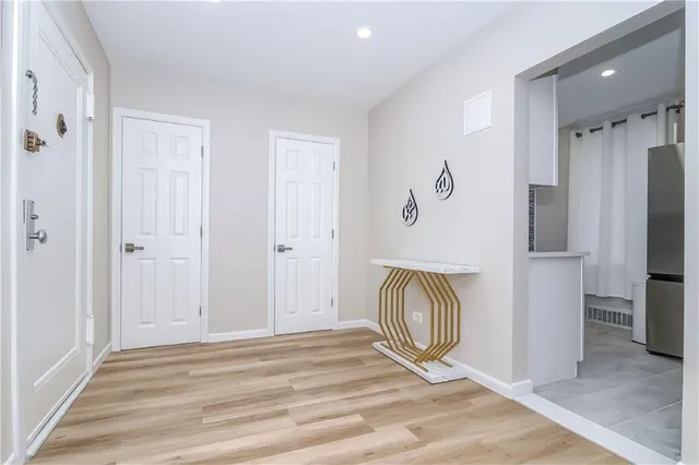 a view of a livingroom with entryway and bedroom with wooden floor