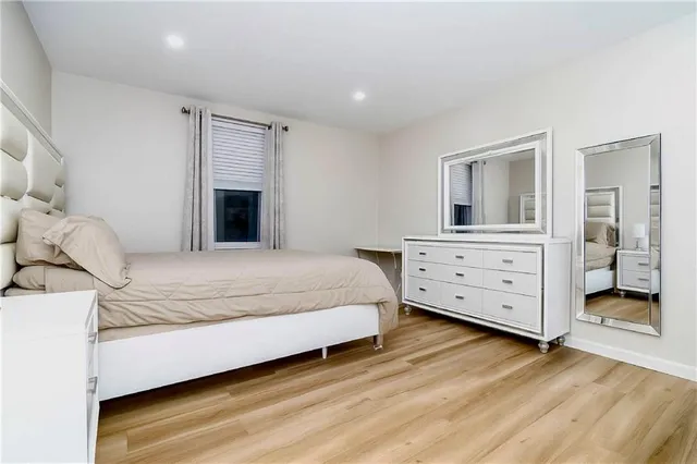 a spacious bedroom with a bed and a dresser