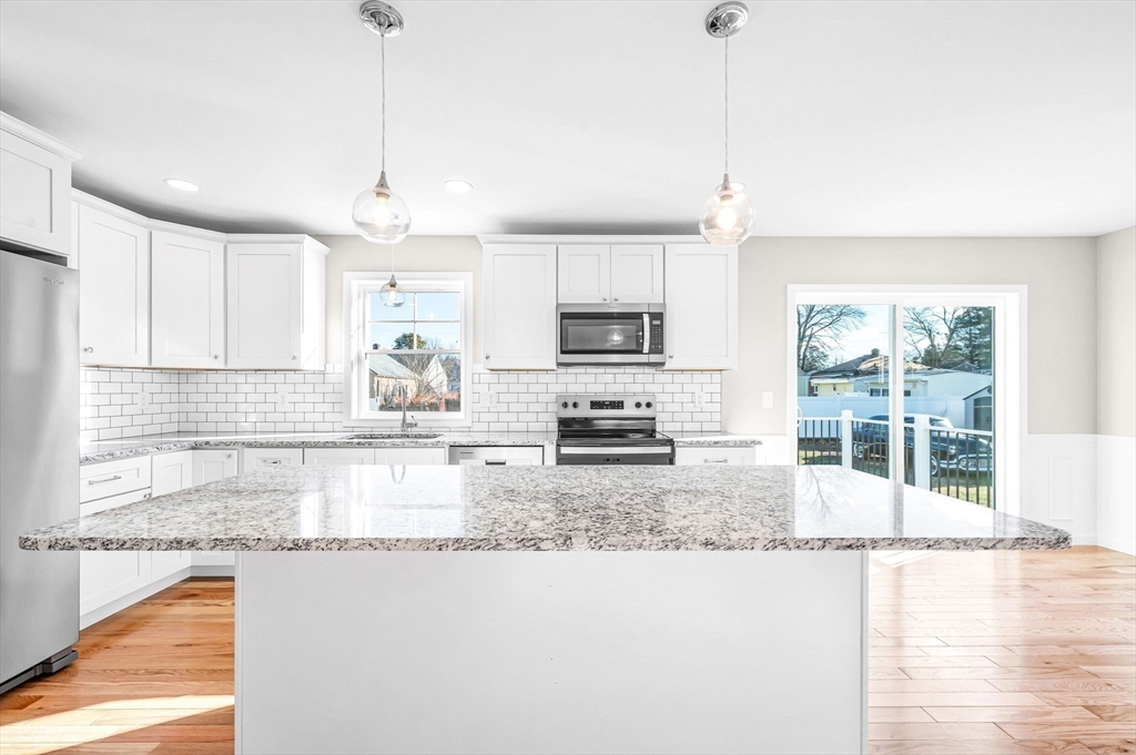 39 Wallace Street Springfield, MA 01119 - Photo 18 of 41 a kitchen with kitchen island granite countertop a stove a sink a granite counter tops and a view of living room