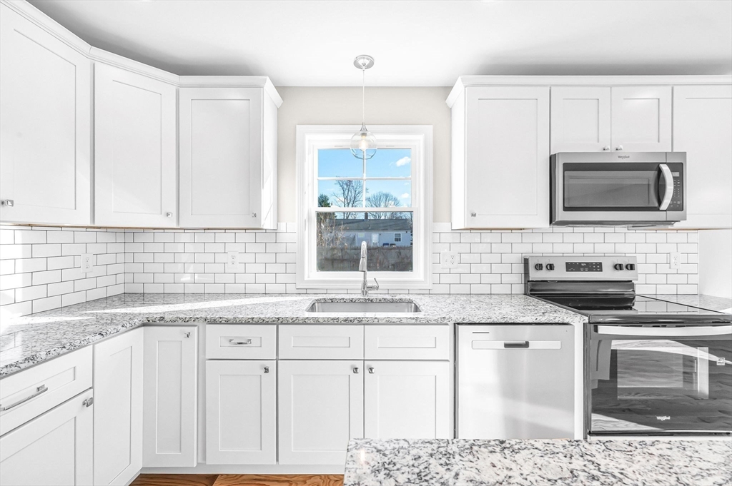 39 Wallace Street Springfield, MA 01119 - Photo 20 of 41 a kitchen with granite countertop a sink stainless steel appliances and white cabinets
