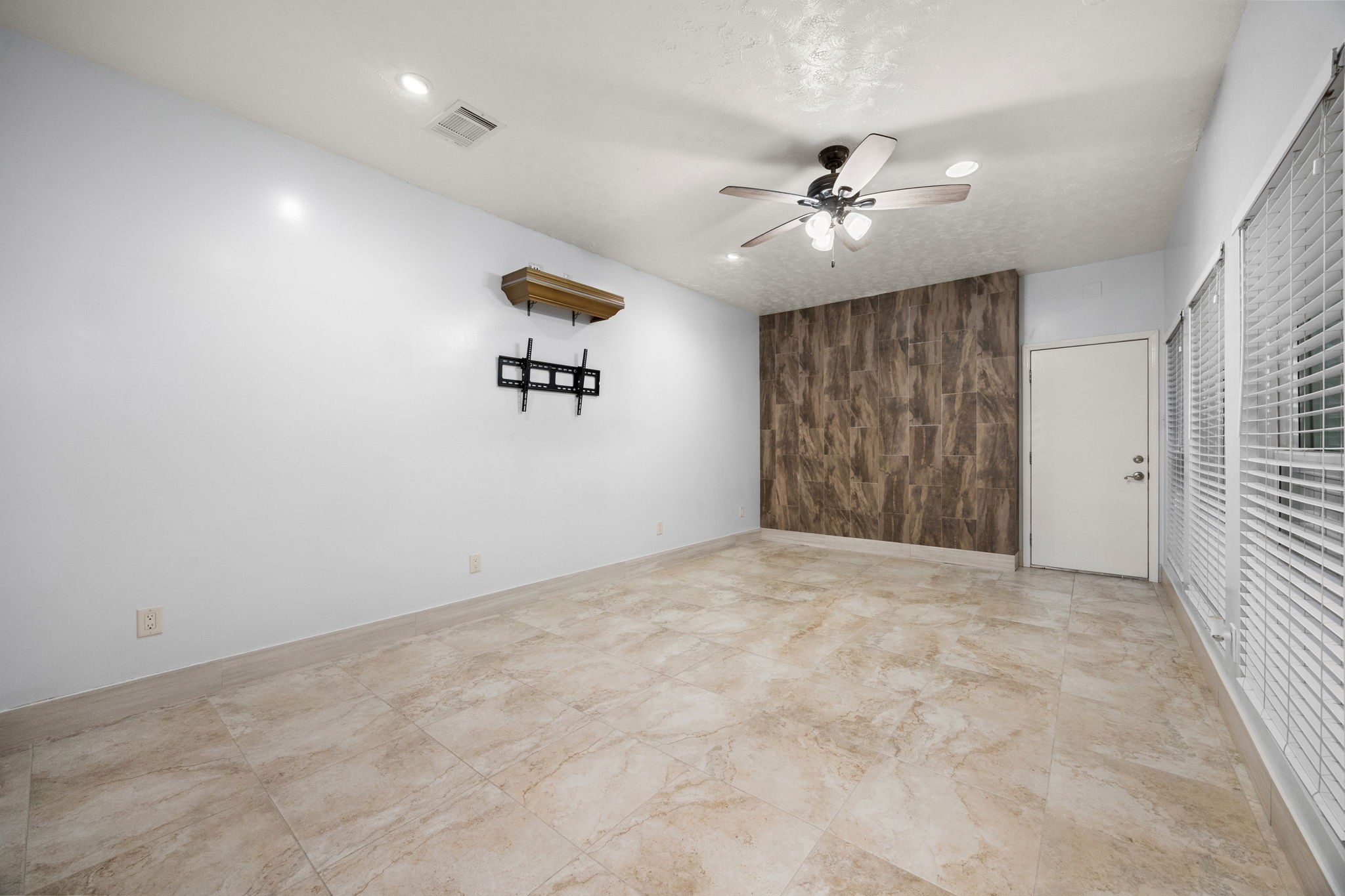 7447 Cambridge Street, Unit 117 Houston, TX 77054 - Photo 10 of 38 an empty room with a ceiling fan and a window