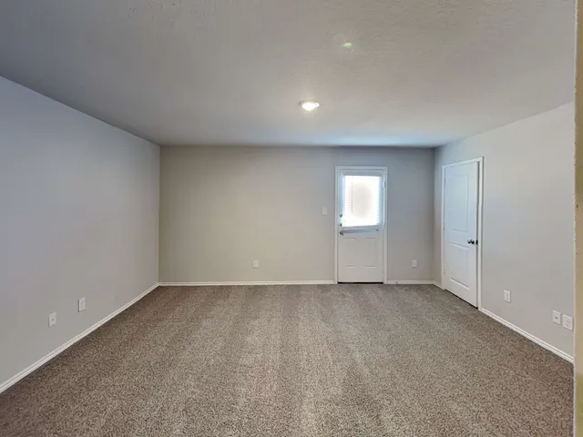 a view of an empty room with a window and closet area