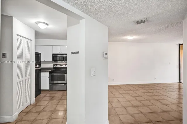 a kitchen with granite countertop a refrigerator and a stove top oven