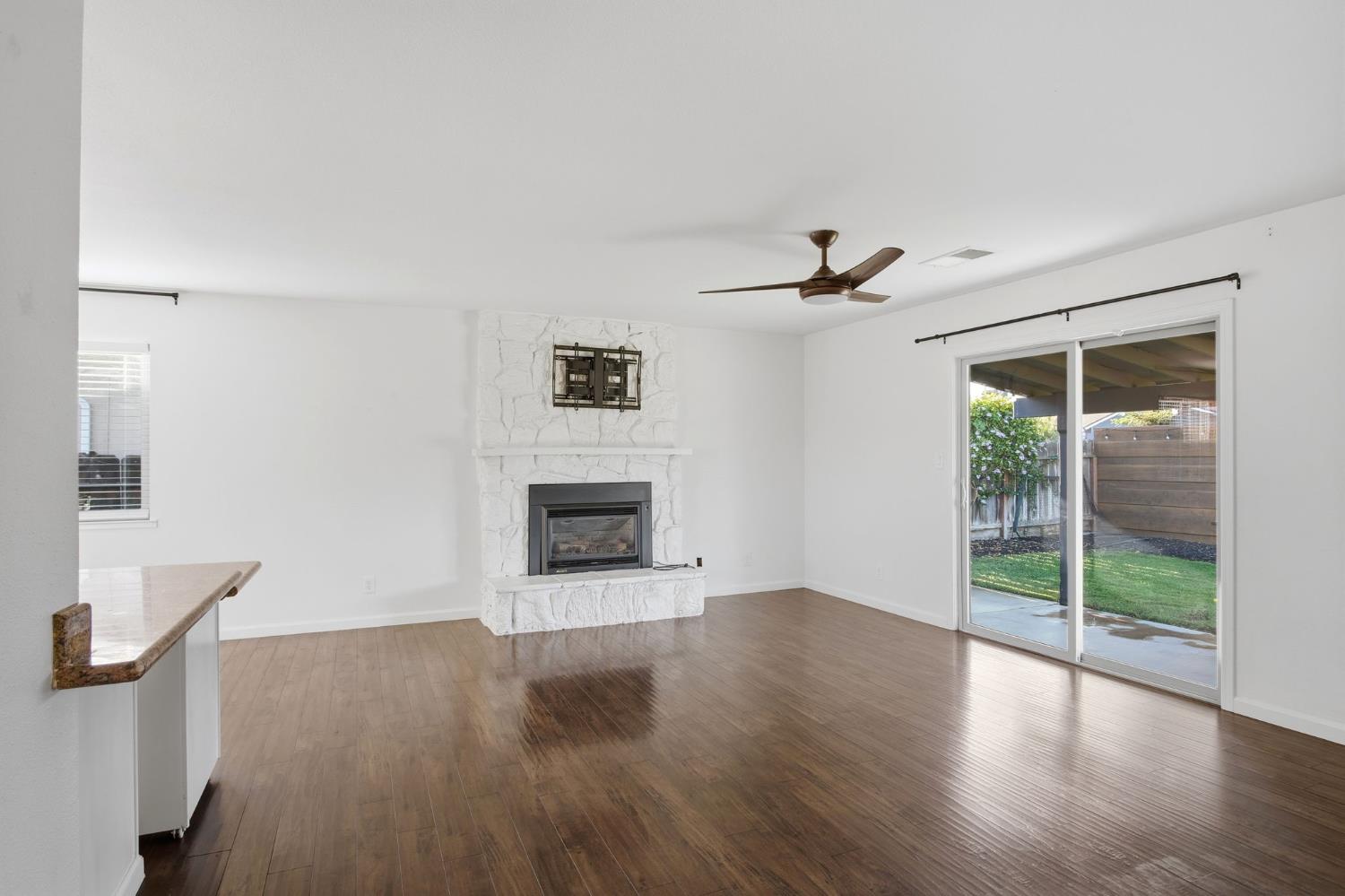 680 Sherri Way Turlock, CA 95382 - Photo 11 of 35 a view of a livingroom with wooden floor a fireplace and a window