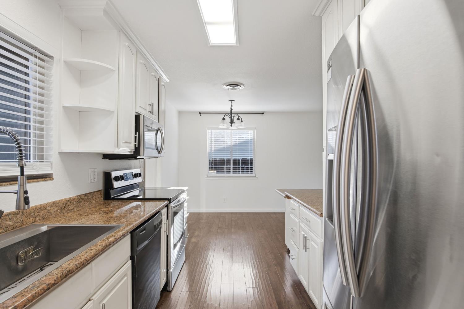 680 Sherri Way Turlock, CA 95382 - Photo 2 of 35 a kitchen with stainless steel appliances granite countertop a sink stove and refrigerator