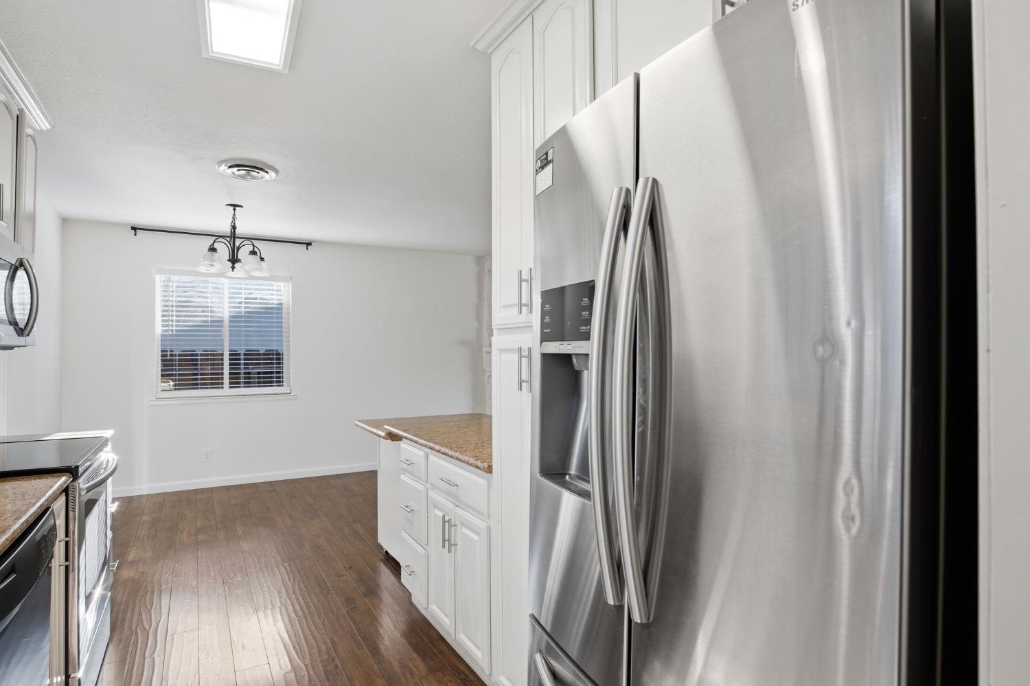 680 Sherri Way Turlock, CA 95382 - Photo 4 of 35 a kitchen with stainless steel appliances a refrigerator and a wooden floor