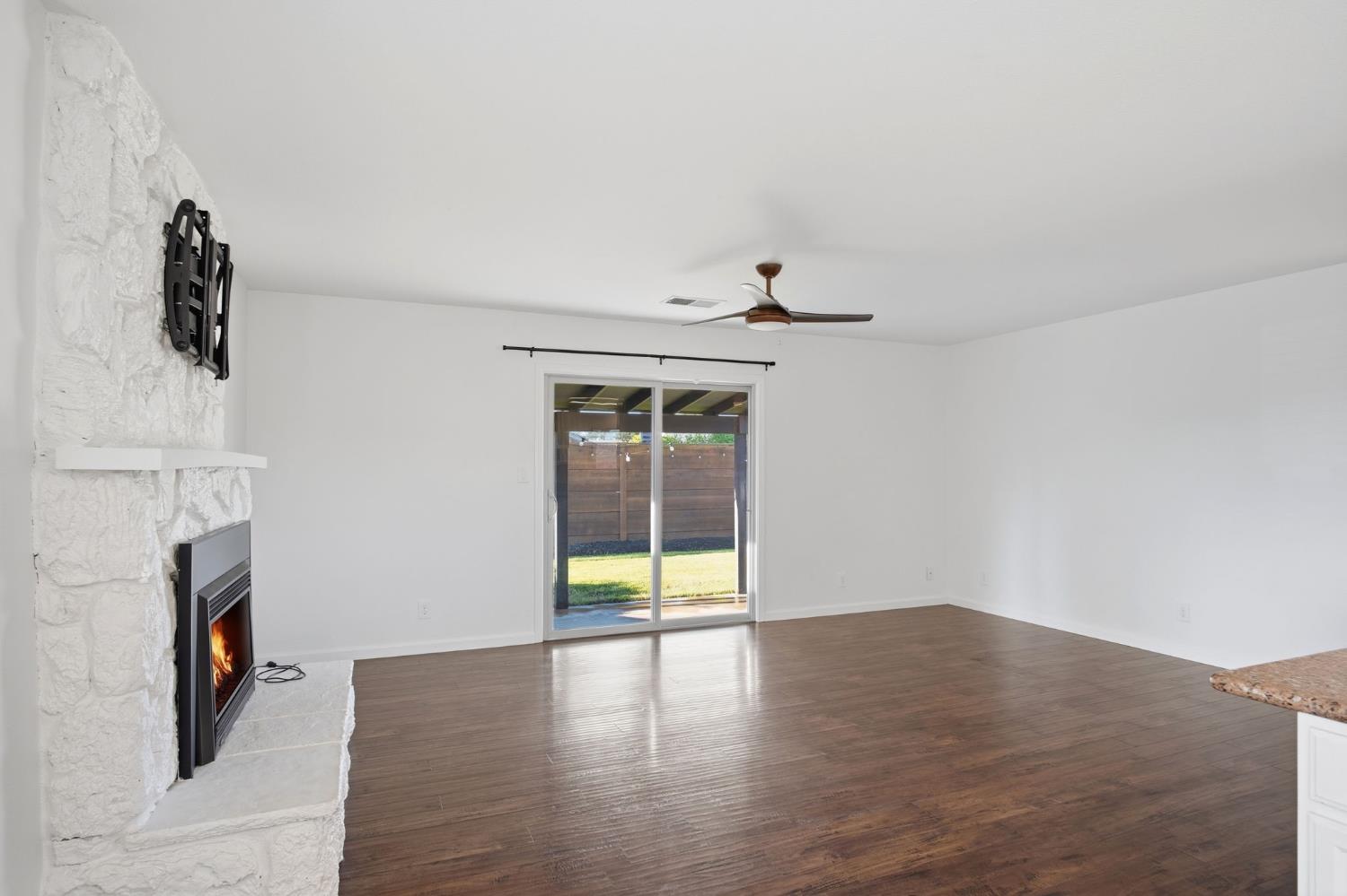 680 Sherri Way Turlock, CA 95382 - Photo 7 of 35 a view of an empty room with wooden floor and a fireplace
