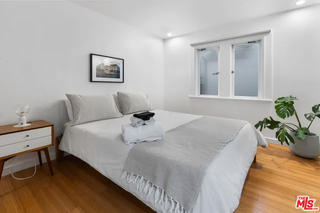 a bedroom with a bed and a potted plant