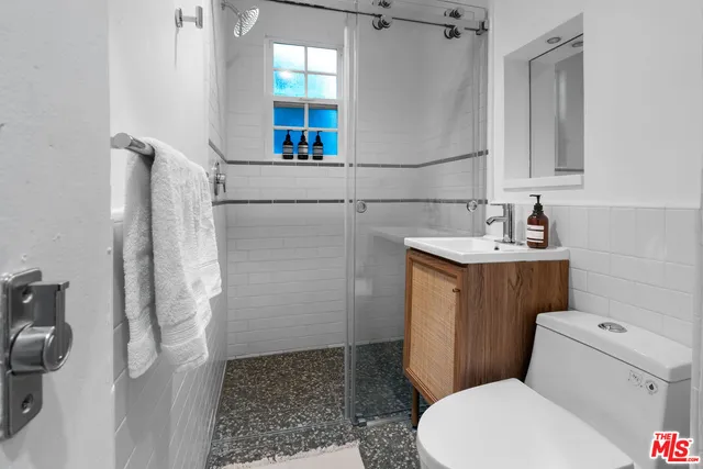 a bathroom with a sink a toilet and shower