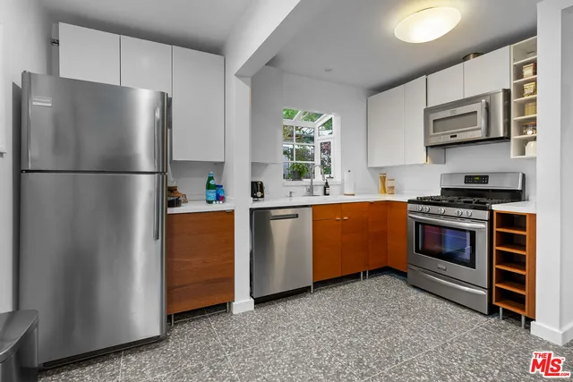 a kitchen with stainless steel appliances a refrigerator stove and microwave