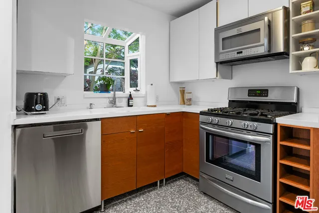 a kitchen with stainless steel appliances a stove a sink and a microwave