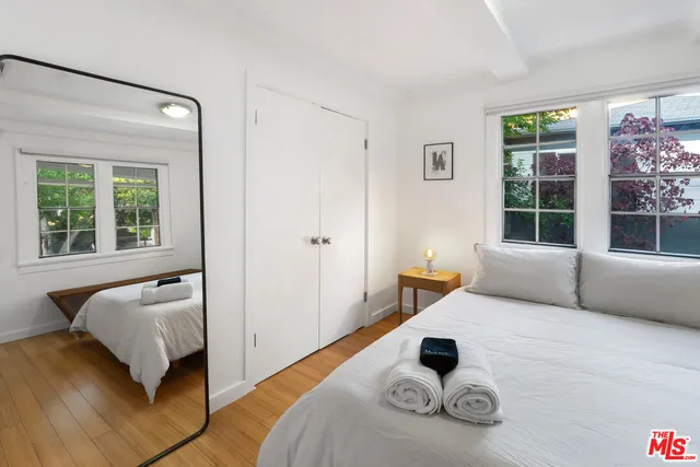 a bedroom with a bed and wooden floor