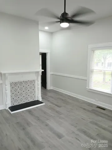 an empty room with wooden floor cabinet and windows