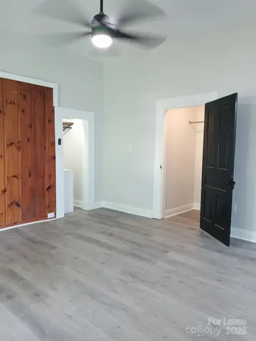 a view of an empty room with wooden floor and a cabinet