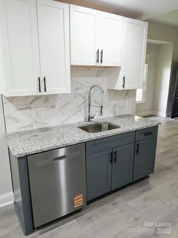 a kitchen with granite countertop a sink and cabinets