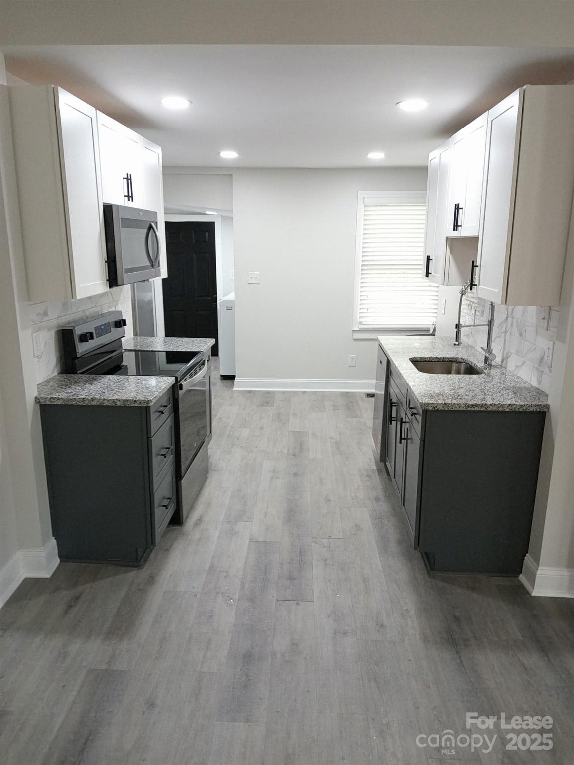 238 South Main Street, Unit A Davidson, NC 28036 - Photo 6 of 11 a kitchen with kitchen island stainless steel appliances a sink stove and refrigerator