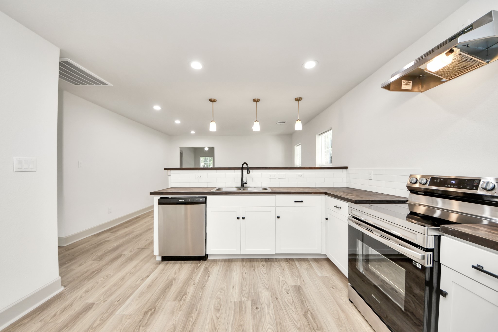 2919 Rosedale Street, Unit B Houston, TX 77004 - Photo 14 of 35 a kitchen with granite countertop white cabinets and white appliances