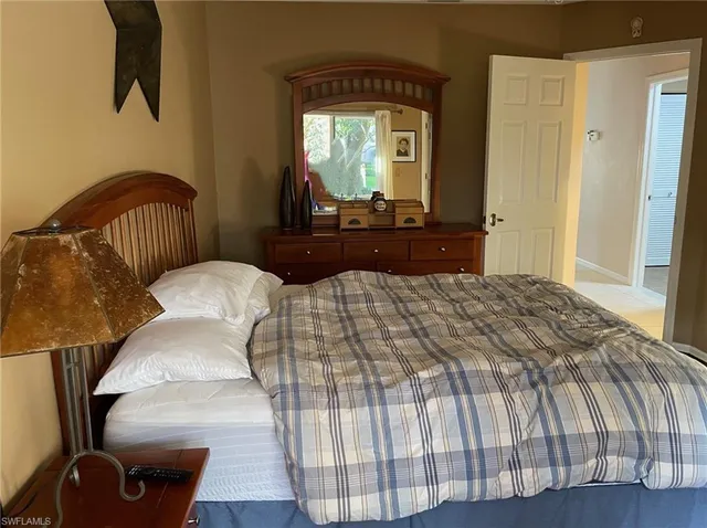 a bedroom with a bed and a mirror