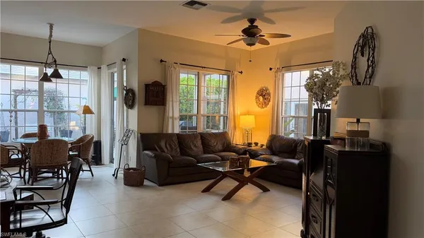 a living room with furniture a chandelier and a window