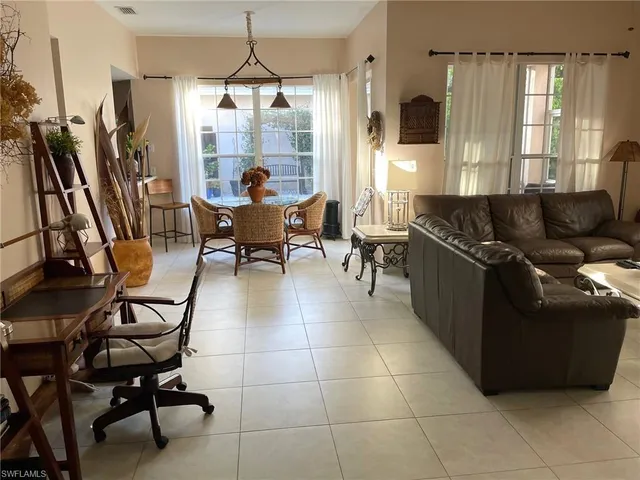 a living room with furniture a flat screen tv and a window