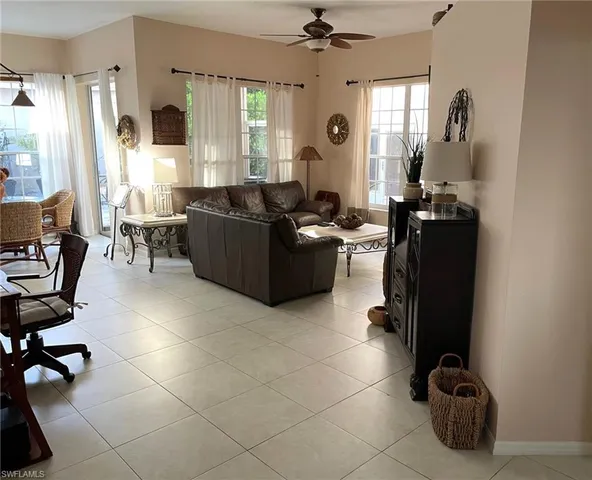 a living room with furniture a dining table and a large window