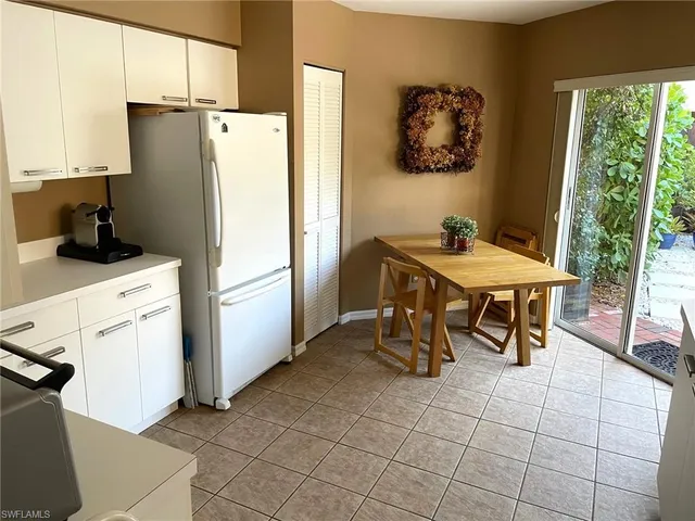 a kitchen with stainless steel appliances a refrigerator a stove a microwave and a dining table