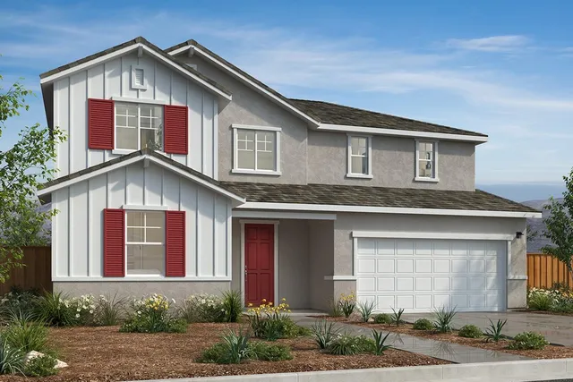 a front view of a house with garage and trees