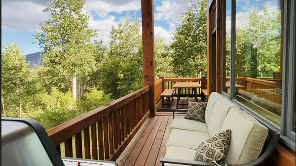 a balcony with wooden floor and outdoor seating