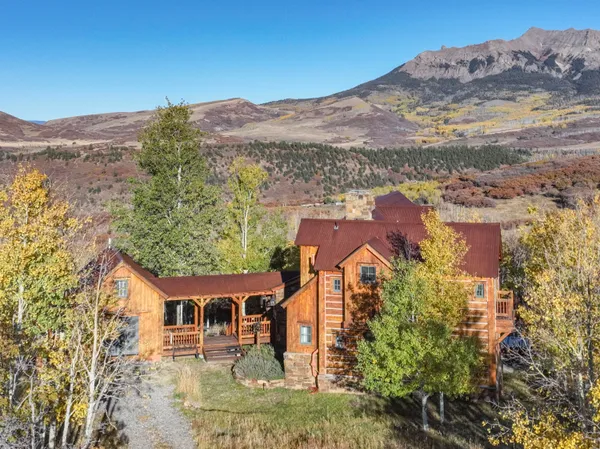 an aerial view of residential houses with outdoor space and trees
