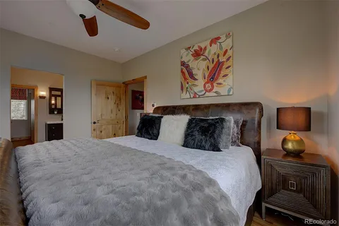 a bedroom with a bed and a lamp on dresser