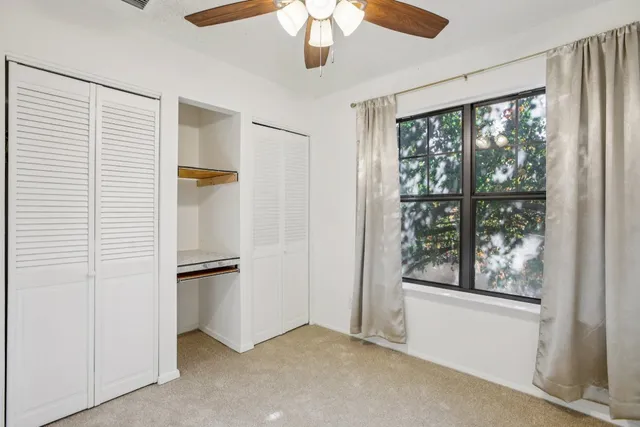 an empty room with windows and cabinet
