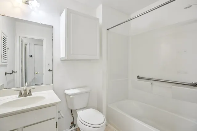 an empty room with a chandelier fan and windows
