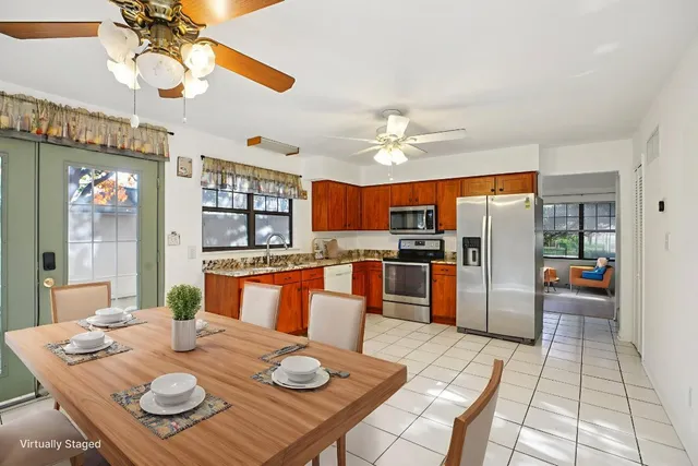 a large kitchen with stainless steel appliances kitchen island granite countertop a refrigerator and a sink