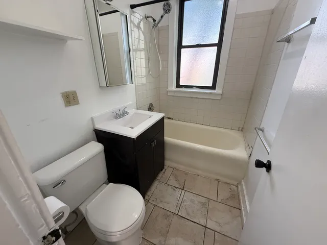 a white toilet sitting next to a bath tub