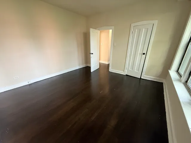 an empty room with wooden floor and a window