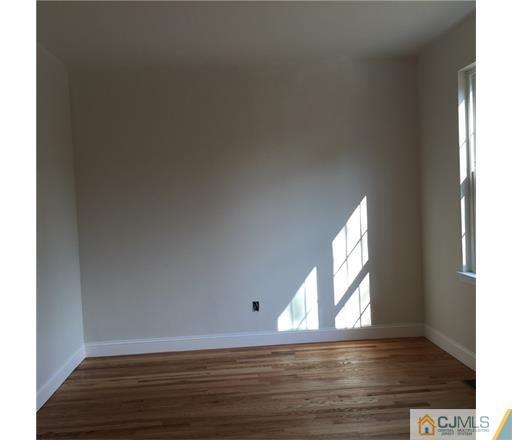 52 West Cliff Road Colonia, NJ 07067 - Photo 16 of 18 an empty room with wooden floor and windows