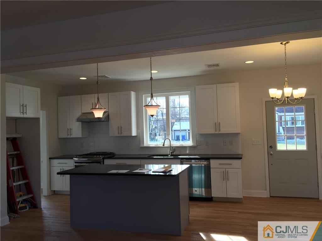 52 West Cliff Road Colonia, NJ 07067 - Photo 3 of 18 a kitchen with granite countertop a sink cabinets and window