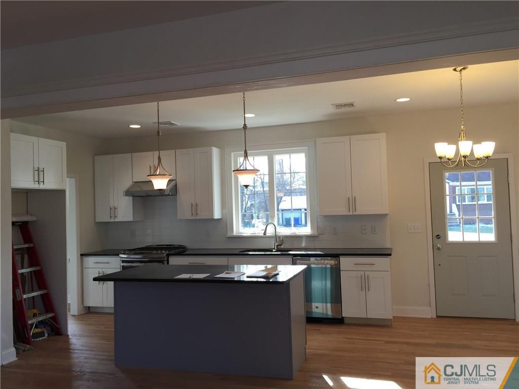 52 West Cliff Road Colonia, NJ 07067 - Photo 4 of 18 a kitchen with granite countertop a sink cabinets and window