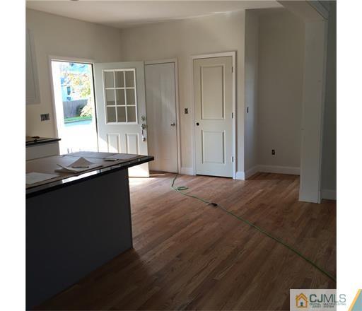 52 West Cliff Road Colonia, NJ 07067 - Photo 8 of 18 an empty room with wooden floor and windows