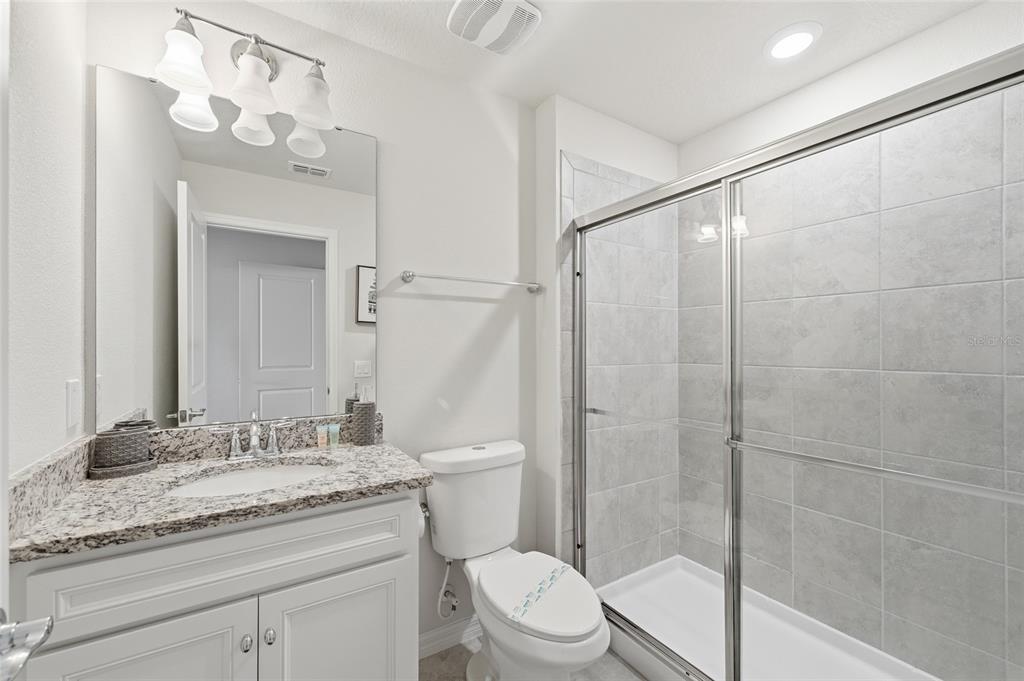 236 Jetty Way Davenport, FL 33897 - Photo 16 of 25 a bathroom with a granite countertop sink a toilet and shower